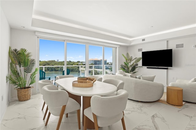 tiled dining space with a raised ceiling