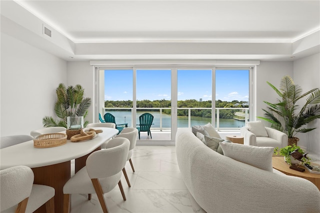 living room with light tile patterned flooring, a healthy amount of sunlight, and a water view