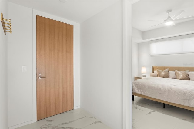 tiled bedroom featuring ceiling fan and a closet