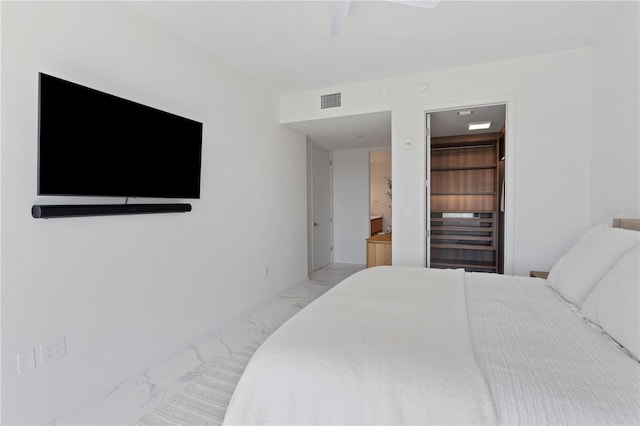 bedroom with ceiling fan, connected bathroom, and light tile patterned floors