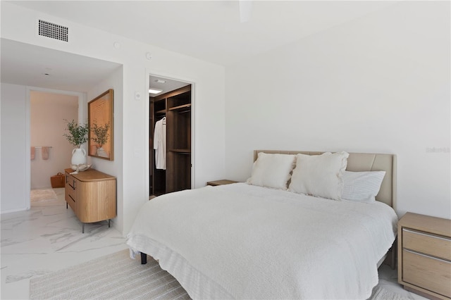 tiled bedroom featuring a closet and a spacious closet