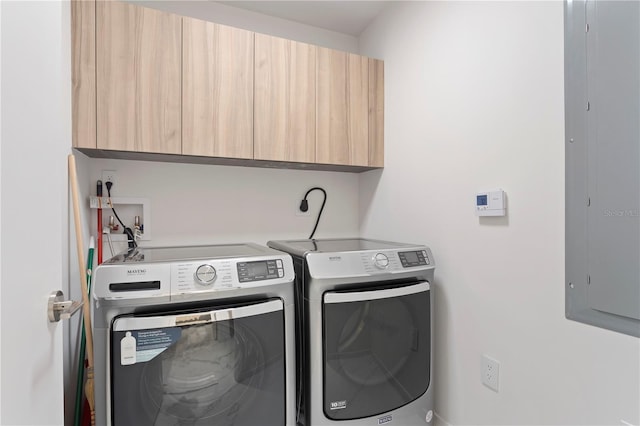 laundry room featuring independent washer and dryer, electric panel, and cabinets