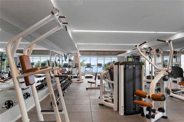 exercise room with plenty of natural light and light tile patterned floors