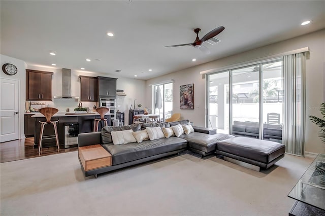 living room featuring ceiling fan and light hardwood / wood-style floors