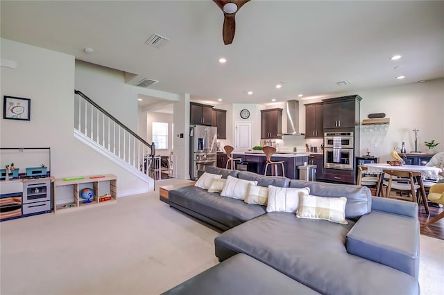 living room with ceiling fan and light colored carpet