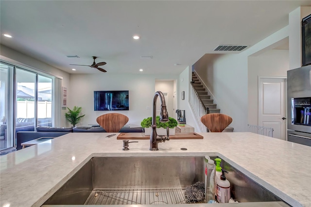 kitchen featuring ceiling fan and stainless steel refrigerator with ice dispenser