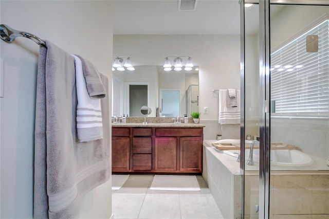 bathroom featuring separate shower and tub, double vanity, and tile patterned flooring