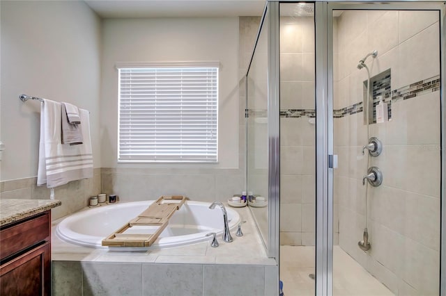 bathroom featuring shower with separate bathtub and vanity