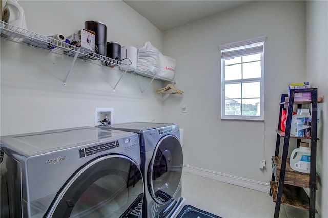 laundry area featuring light tile patterned floors and washing machine and clothes dryer