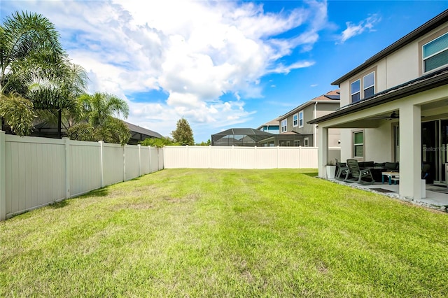 view of yard with ceiling fan and a patio