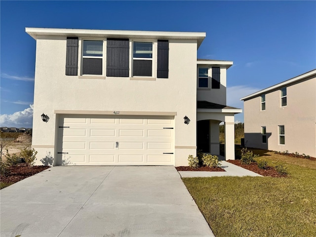 view of front of property featuring a garage, driveway, and stucco siding