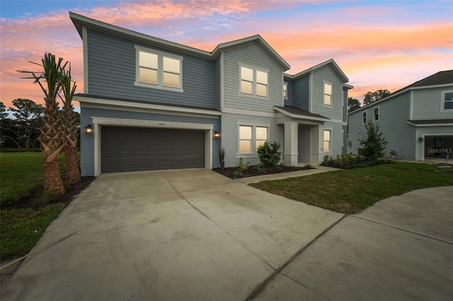 view of front of home with a garage and a yard