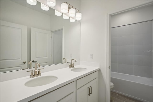 full bathroom with wood-type flooring, vanity, shower / bath combination, and toilet