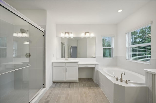 bathroom with vanity, wood-type flooring, and shower with separate bathtub