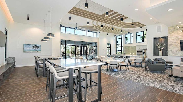 dining room with dark hardwood / wood-style flooring and a high ceiling