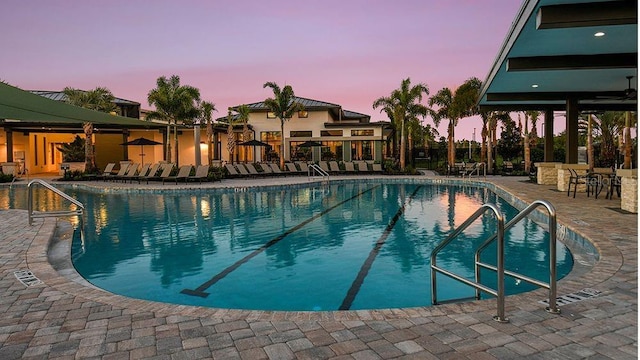 pool at dusk with a patio