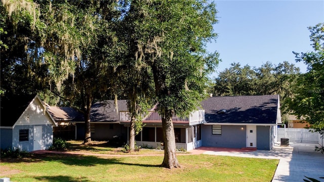 ranch-style house with cooling unit, a patio, a shed, and a front lawn