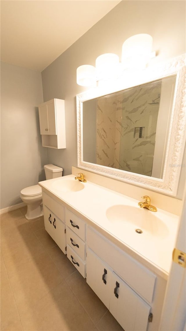 bathroom with tile patterned floors, double vanity, and toilet