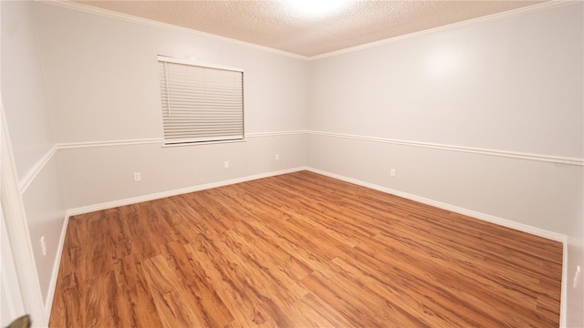 empty room featuring a textured ceiling, crown molding, and hardwood / wood-style floors