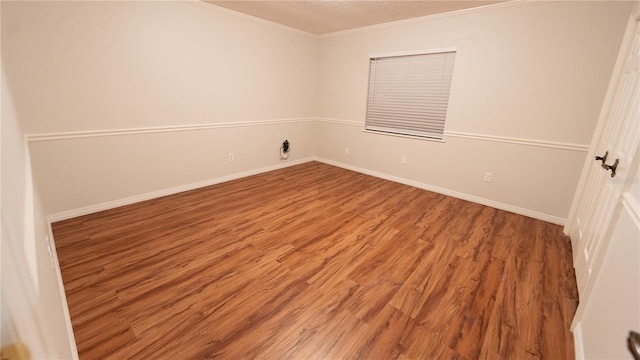 empty room with crown molding and hardwood / wood-style floors