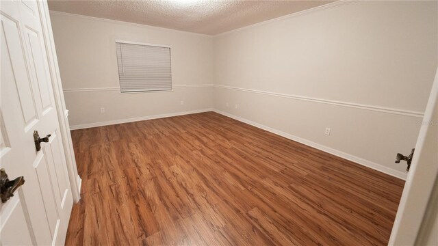 unfurnished room featuring wood-type flooring and a textured ceiling