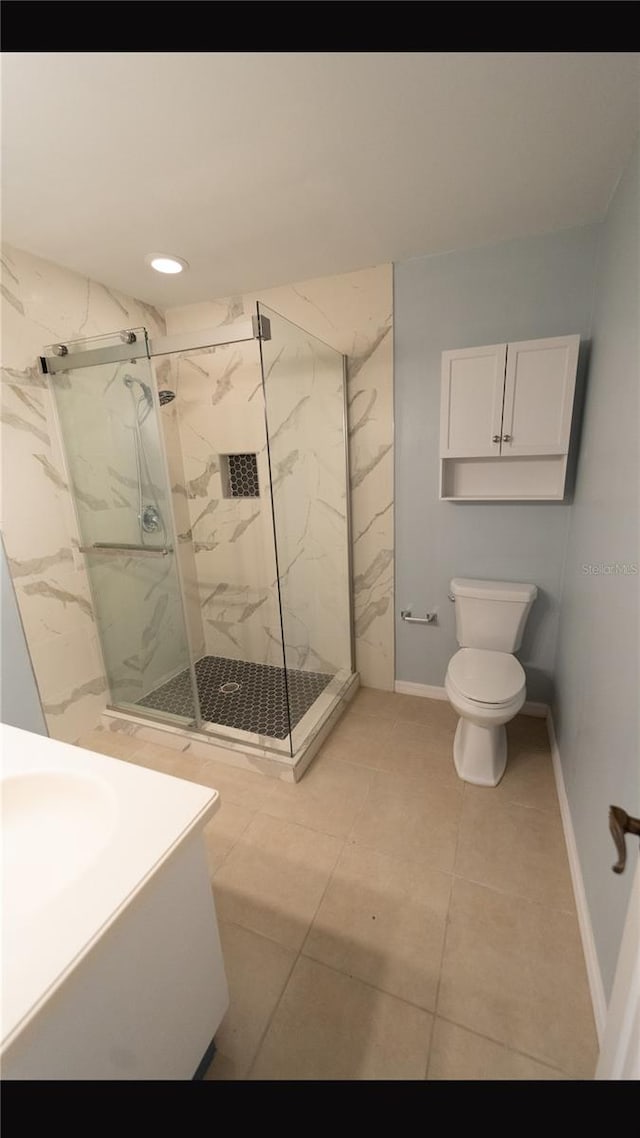 bathroom featuring toilet, walk in shower, tile patterned flooring, and vanity