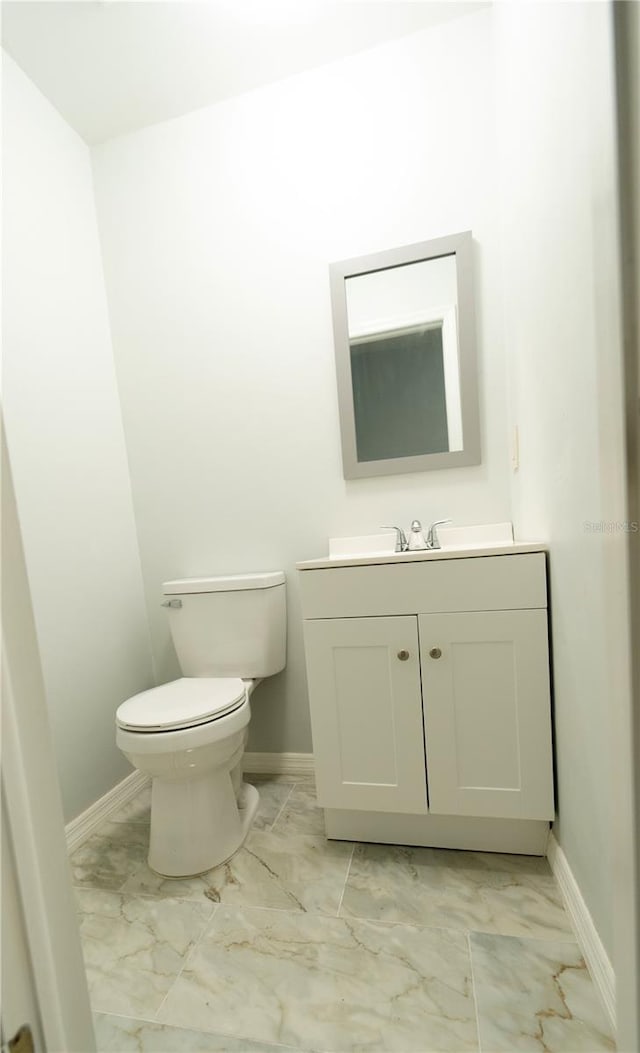 bathroom with tile patterned flooring, vanity, and toilet