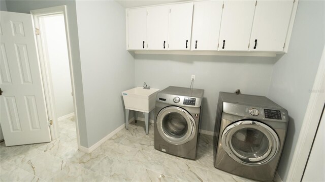 laundry area featuring light tile patterned floors, cabinets, and washer and dryer