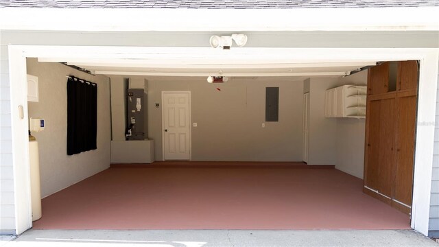 garage featuring a garage door opener, heating unit, and electric panel