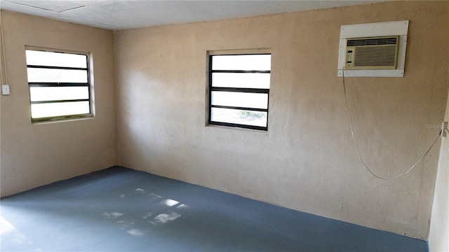 spare room featuring concrete floors and a wall mounted air conditioner