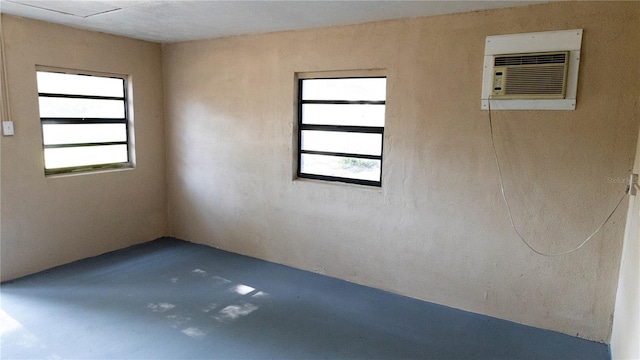 empty room featuring a healthy amount of sunlight and a wall mounted air conditioner