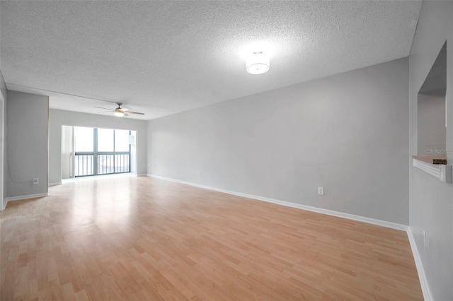 empty room with ceiling fan, light hardwood / wood-style floors, and a textured ceiling