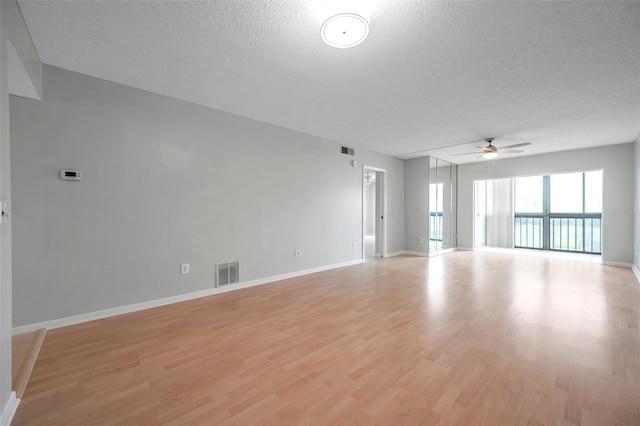 unfurnished room featuring ceiling fan, light hardwood / wood-style floors, and a textured ceiling