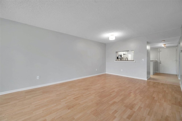 spare room featuring light hardwood / wood-style flooring and a textured ceiling