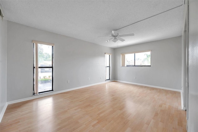 unfurnished room featuring ceiling fan, plenty of natural light, light hardwood / wood-style flooring, and a textured ceiling