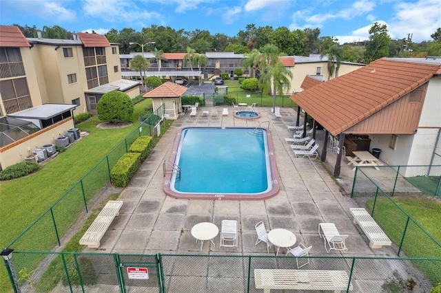 view of pool with a yard, a gazebo, a community hot tub, and a patio area