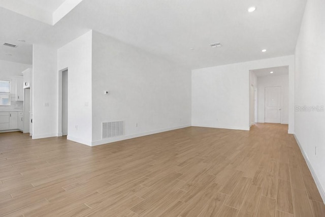 unfurnished living room with light wood-style floors, recessed lighting, visible vents, and baseboards