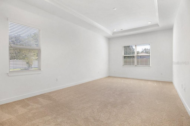 spare room featuring light carpet, baseboards, a tray ceiling, and recessed lighting