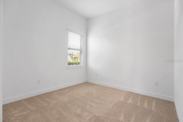 carpeted spare room with baseboards