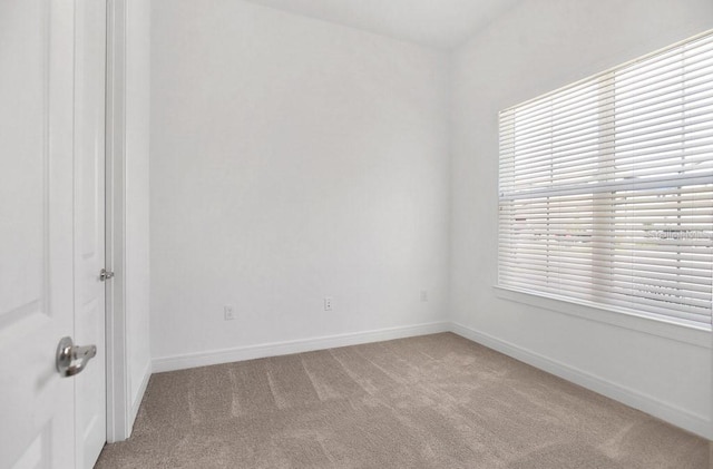 empty room with light carpet and baseboards