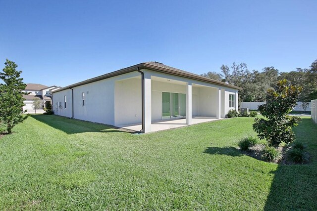 rear view of house featuring a patio and a yard