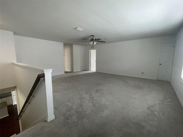 carpeted empty room with a textured ceiling and ceiling fan