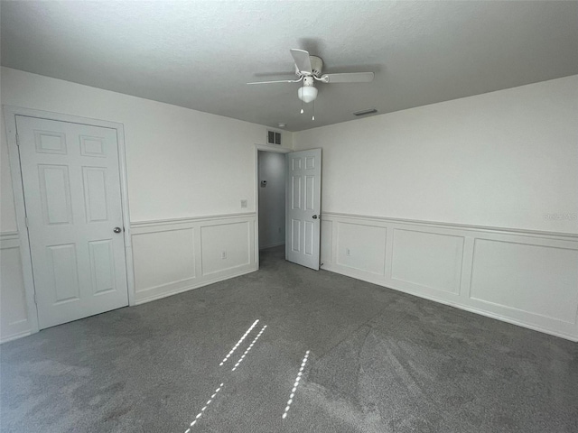 unfurnished bedroom with dark colored carpet and ceiling fan