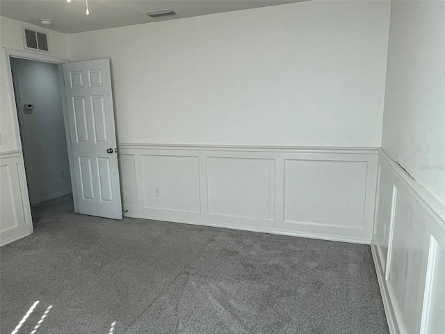 unfurnished room with dark carpet