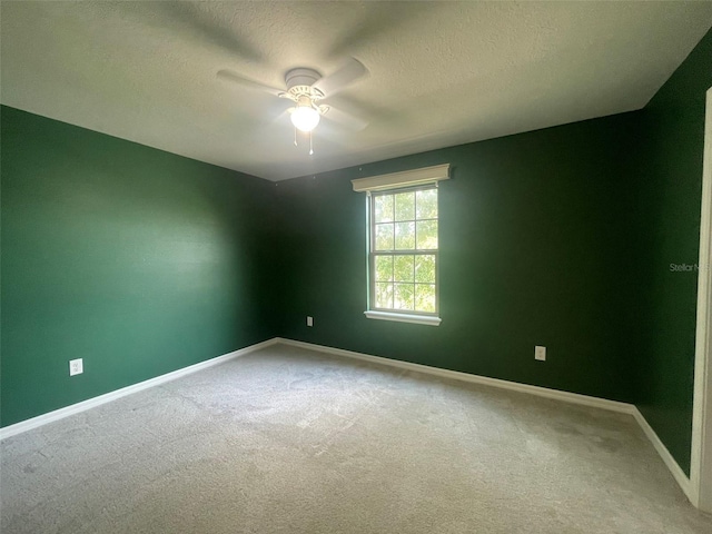 carpeted spare room featuring ceiling fan and a textured ceiling