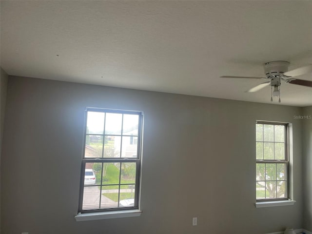 spare room with a textured ceiling and ceiling fan