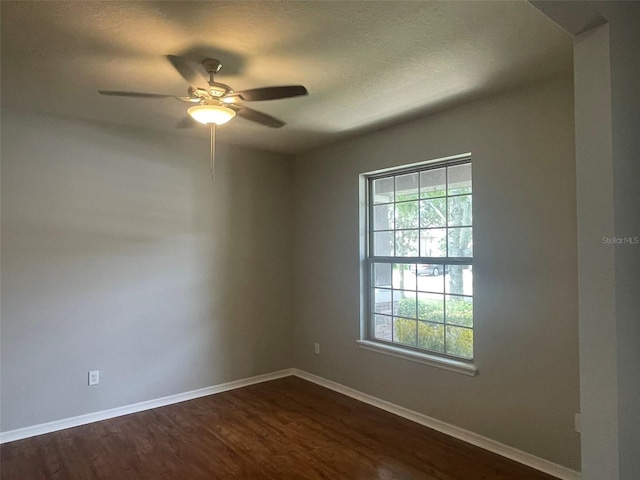 empty room featuring ceiling fan and dark hardwood / wood-style flooring