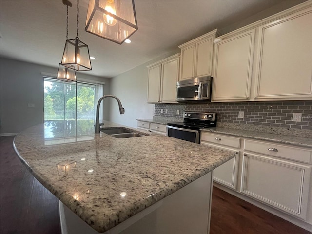 kitchen featuring sink, electric range oven, and a center island with sink