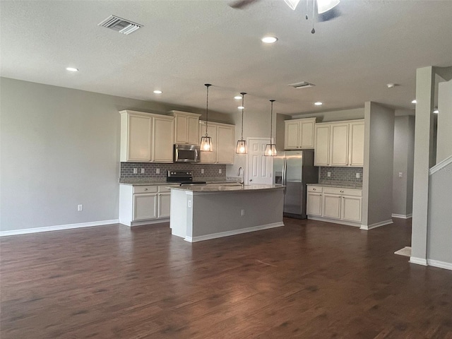 kitchen featuring a center island with sink, appliances with stainless steel finishes, dark hardwood / wood-style flooring, and decorative light fixtures