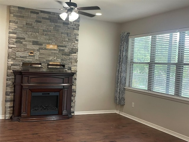 unfurnished living room with dark hardwood / wood-style flooring, ceiling fan, and a fireplace